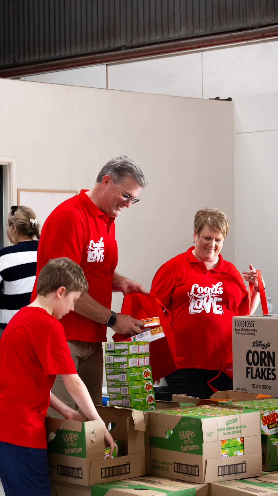 Loads of Love volunteers packing hampers, documented by Wave Creative