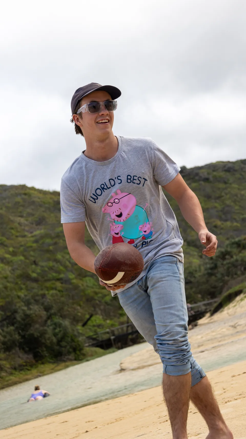 Man holding a football on a coastal track