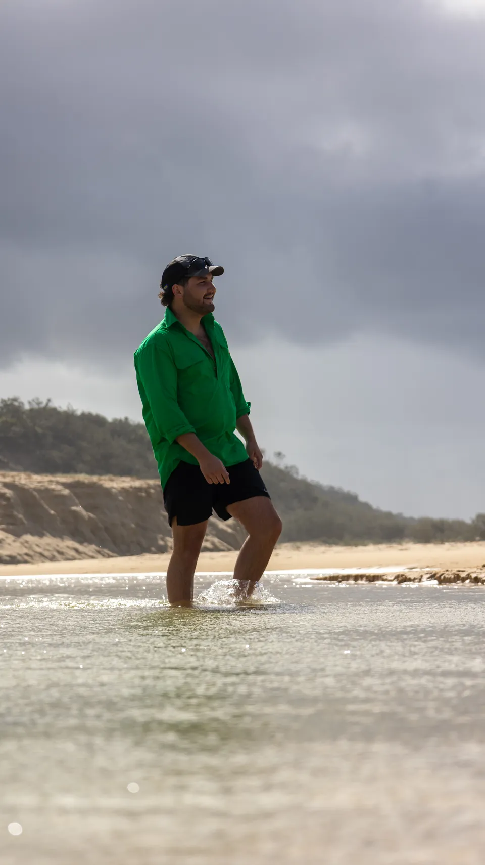 Man in a green shirt standing in shallow water